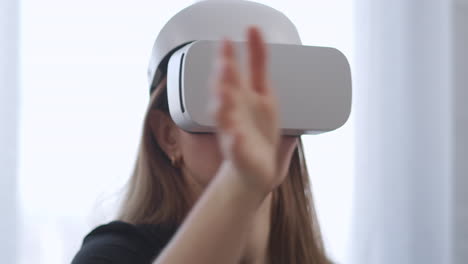 closeup-portrait-of-young-woman-using-HMD-display-in-home-moving-hands-for-controlling-modern-technology-of-video-games-and-education-interactive-learning